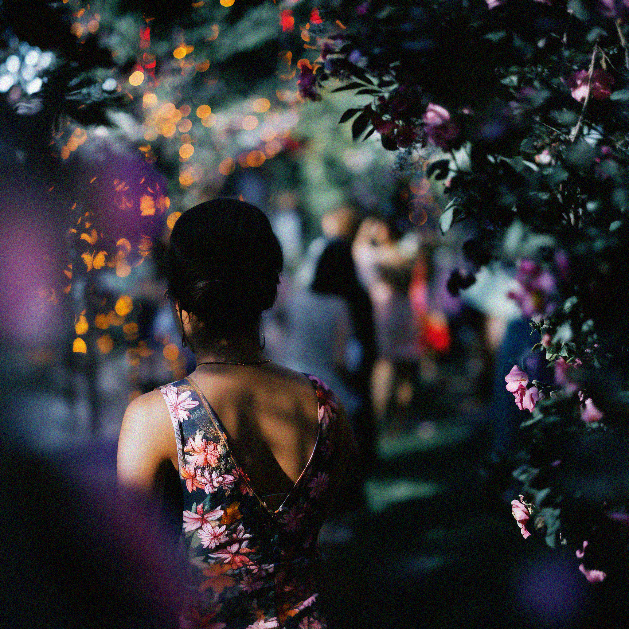 woman walking through a floral archway