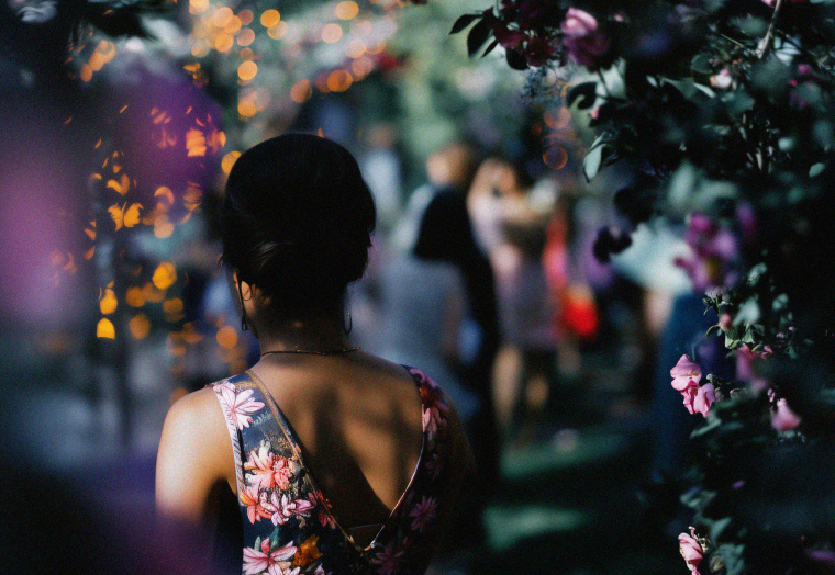 woman walking through a floral archway